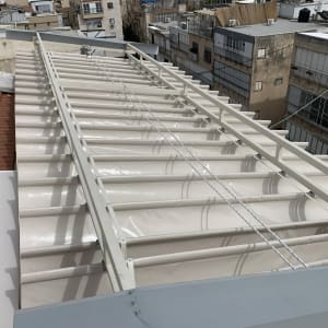 סוכך לבן עם קורות מתכת על גג בניין