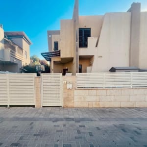 גדרות לבנים עם מסגרות מתכת לבנות בחזית הבית