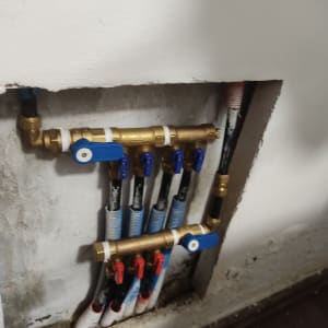 צינורות מים עם ברזים כחולים ואדומים בקיר