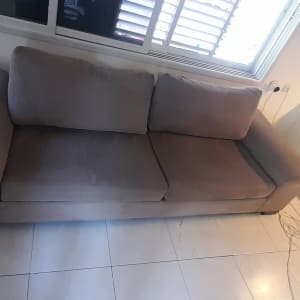 ספה אפורה על רצפת אריחים לבנים ליד חלון