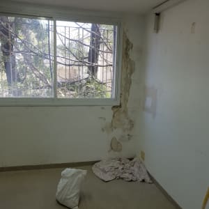 קיר מתקלף עם תיקוני צבע, שקית וחומרי עבודה