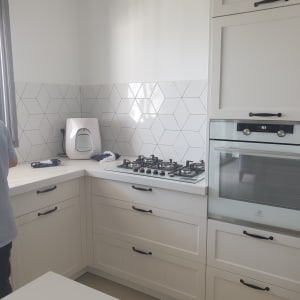 מטבח עם כיריים ותנור חדשים, אריחים משושים על הקיר