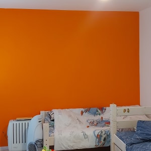 קיר צבוע בכתום בחדר שינה