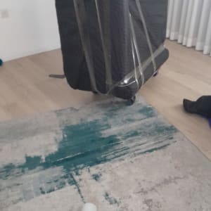 רהיט עטוף בניילון עם גלגלים על שטיח