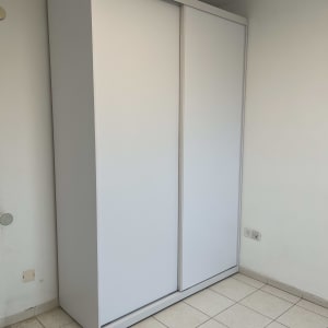 ארון לבן עם דלתות הזזה בחדר ריק