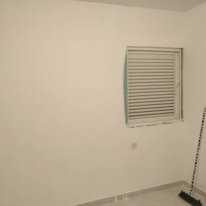 קיר עם חלון ותריס, מטאטא עומד בפינה