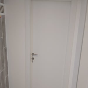 דלת לבנה עם ידית מתכת ומנעול