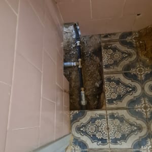 צינור מים חשוף ברצפה עם חיבורים