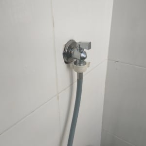 ברז מים עם צינור מחובר לקיר