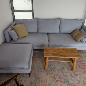 ספה אפורה עם כריות על שטיח צבעוני