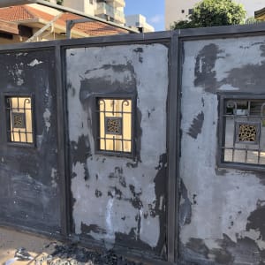 שער מתכת צבוע חלקית עם חלונות קטנים