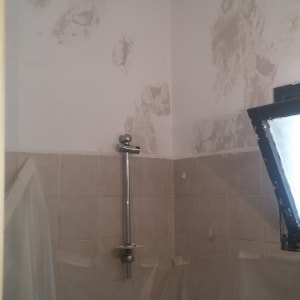 קיר עם תיקוני טיח ופלסטיק להגנה על הרצפה