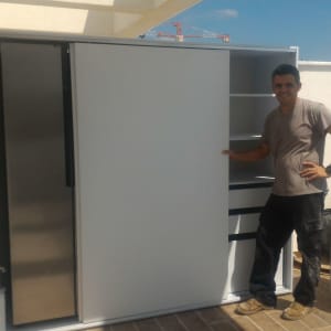 נגר מציג ארון עם דלתות הזזה ומדפים