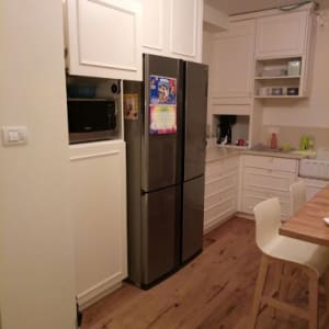 רצפת פרקט עץ במטבח מודרני עם מקרר כסוף