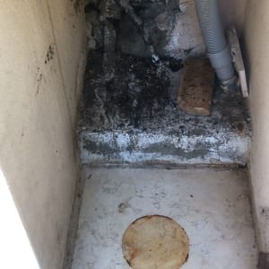 צינור גמיש ליד קיר עם טיח מתקלף