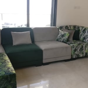 ספה עם ריפוד עלים ירוקים וכריות אפורות