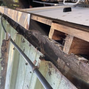 גג מתכת עם נזקי חלודה ועץ חשוף