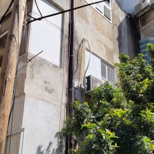 עמוד חשמל עם כבלים ליד בניין מגורים