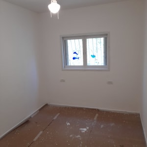 חדר עם קירות צבועים ונייר על הרצפה