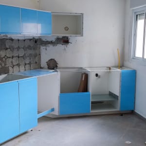 ארונות מטבח כחולים מותקנים על קיר חשוף