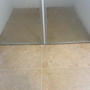 מקלחון עם דלתות זכוכית ורצפת אריחים