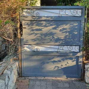 שער מתכת אפור עם עיטורים דקורטיביים