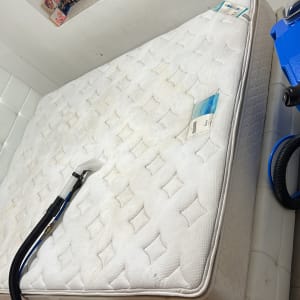 מכונת ניקוי כחולה על מזרן לבן