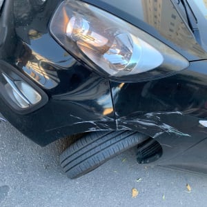 שריטות על פגוש רכב שחור עם פנס קדמי