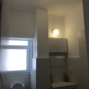 חדר אמבטיה עם קירות צבועים בלבן ותאורה עליונה