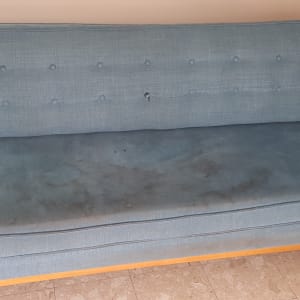 ספה כחולה עם כתמים ולכלוך על המושב