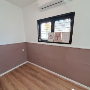 רצפת פרקט עץ בחדר עם קירות לבנים