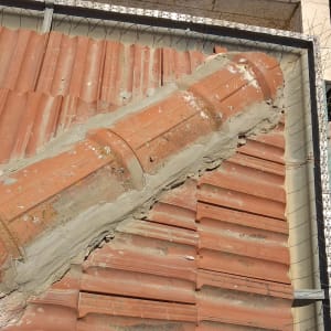 רעפים אדומים עם תיקוני בטון על גג