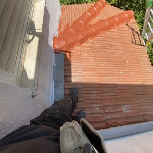 גג רעפים עם צינורות כתומים ועובד על הגג