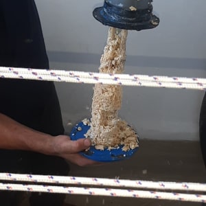 יד מחזיקה צינור עם שבבי עץ נופלים