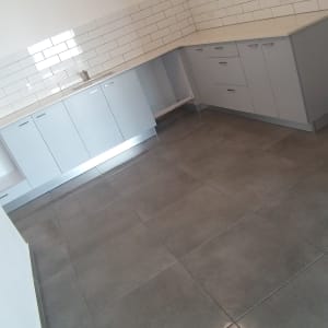 מטבח נקי עם ארונות ומשטח עבודה לבן