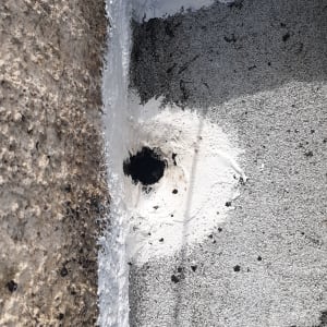 חור אטום בחומר איטום לבן על קיר בטון