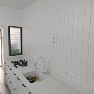 מטבח עם ארונות לבנים וכיריים עליונים