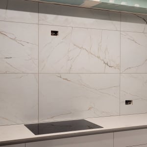 קיר מטבח עם אריחי שיש ולוח חשמל פתוח