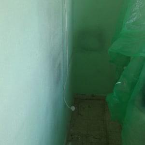 קיר צבוע בירוק עם כתם תיקון לבן