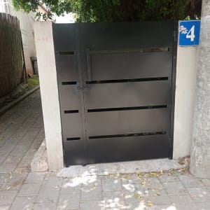 שער מתכת שחור עם ידית ומספר 4 על עמוד