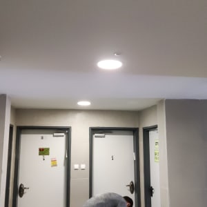 חשמלאי עובד עם כלים ליד דלתות בבניין