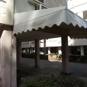 סוכך לבן עם קצוות גליים מחובר לבניין