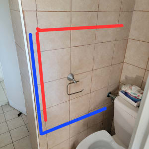 מתקן לנייר טואלט על קיר אריחים בחדר שירותים