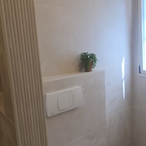 חדר שירותים עם אסלה וקיר אריחים