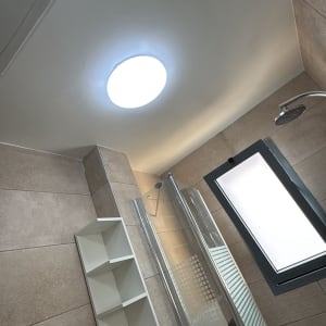 חדר אמבטיה עם מקלחון, מדף ותאורה חדשה