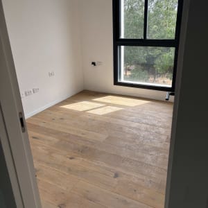 רצפת פרקט עץ בחדר עם חלון גדול