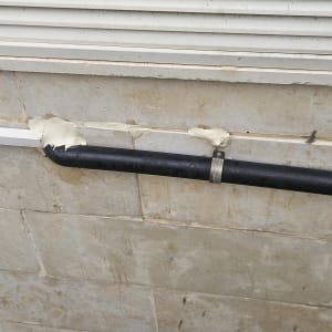 צינור אטום עם חומר איטום על קיר חיצוני