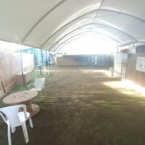 אזור מקורה עם דשא מלאכותי וכיסאות פלסטיק