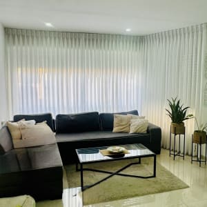 וילון לבן ארוך מכסה חלון גדול בסלון