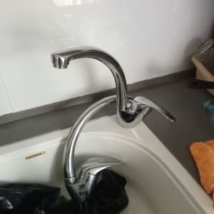 ברז מטבח עם כיור לבן ושקית שחורה